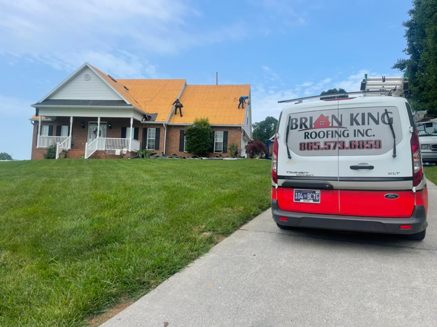 Brian King Roofing van in front of a brick home during a roof installation