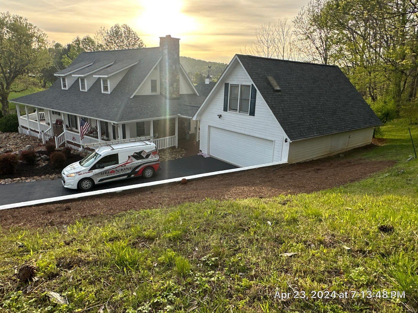Brian King Roofing van parked at a home with a new roof at sunset